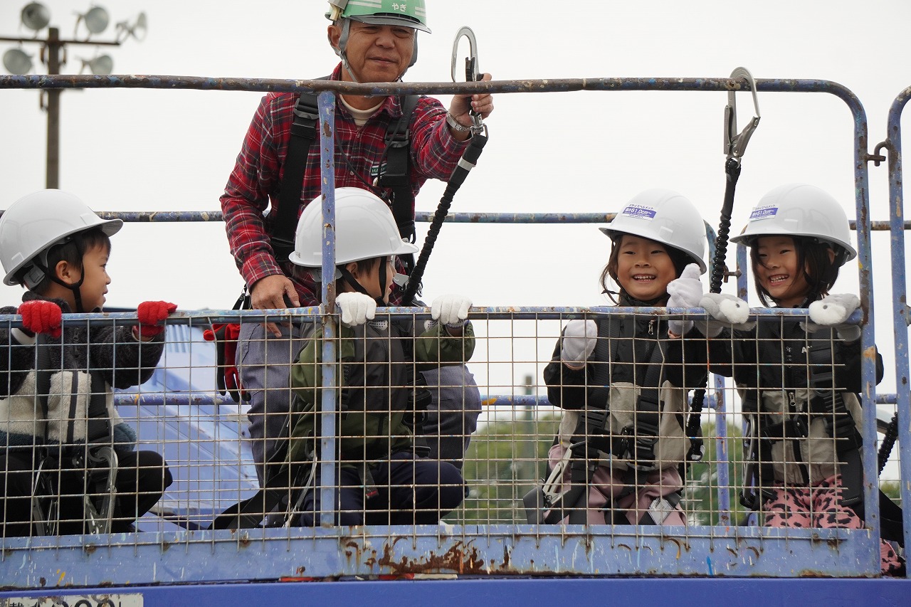 ショベルカーの掘削デモを見学する児童たち