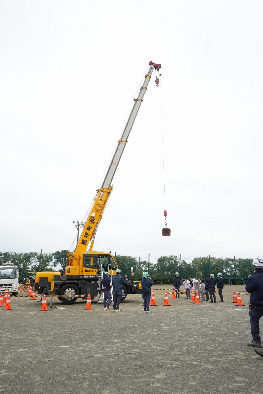 ショベルカーの操作方法について説明を受ける児童