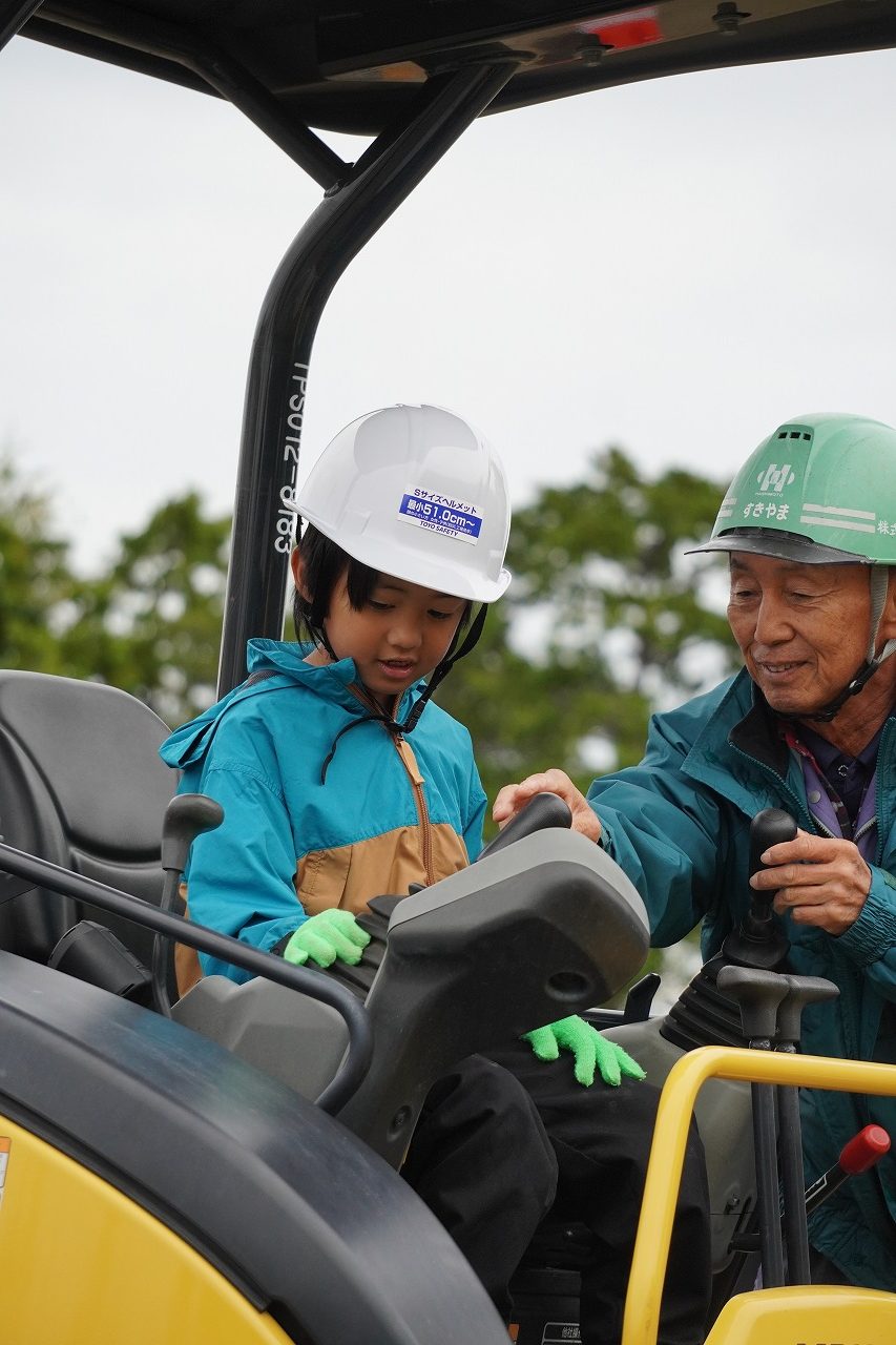 ラフタークレーンの吊り上げ実演を見学する児童たち