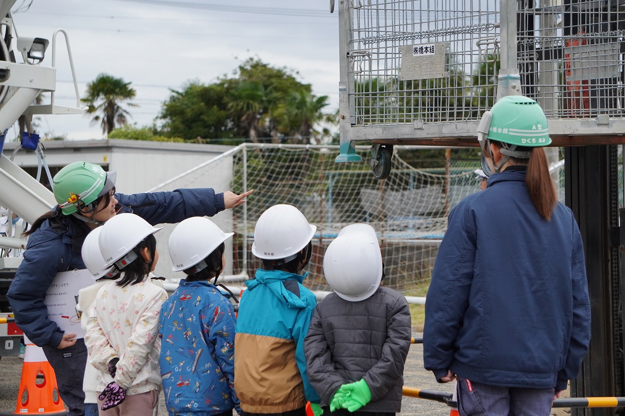 建設機械の仕組みについて、社員の説明を聞く児童たち